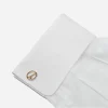 1970s gold tone openwork cufflink styled on a white French cuff shirt.