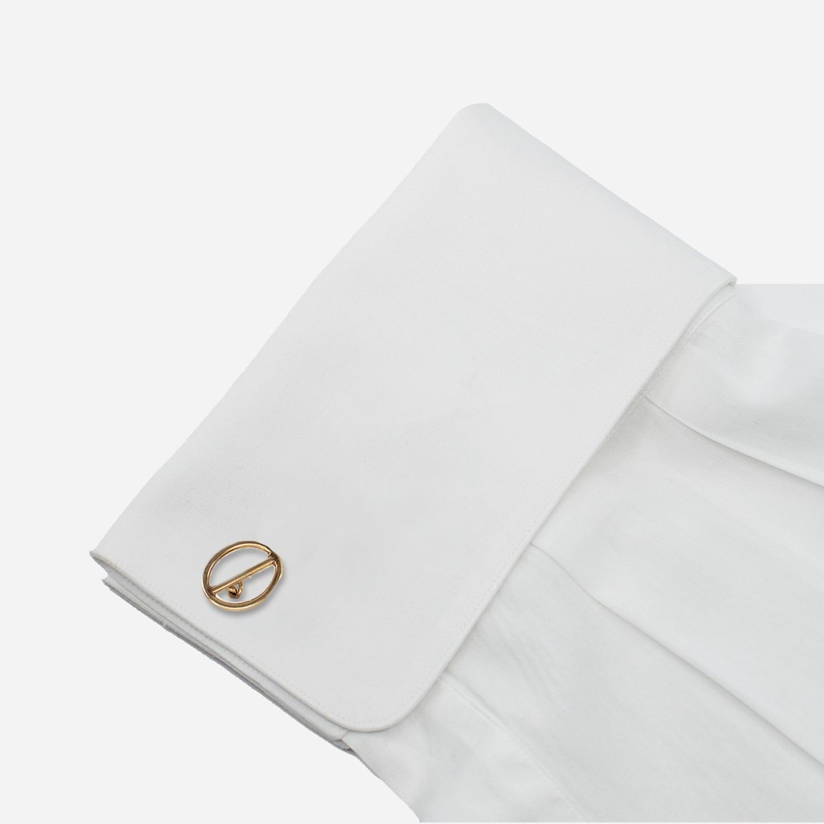 1970s gold tone openwork cufflink styled on a white French cuff shirt.