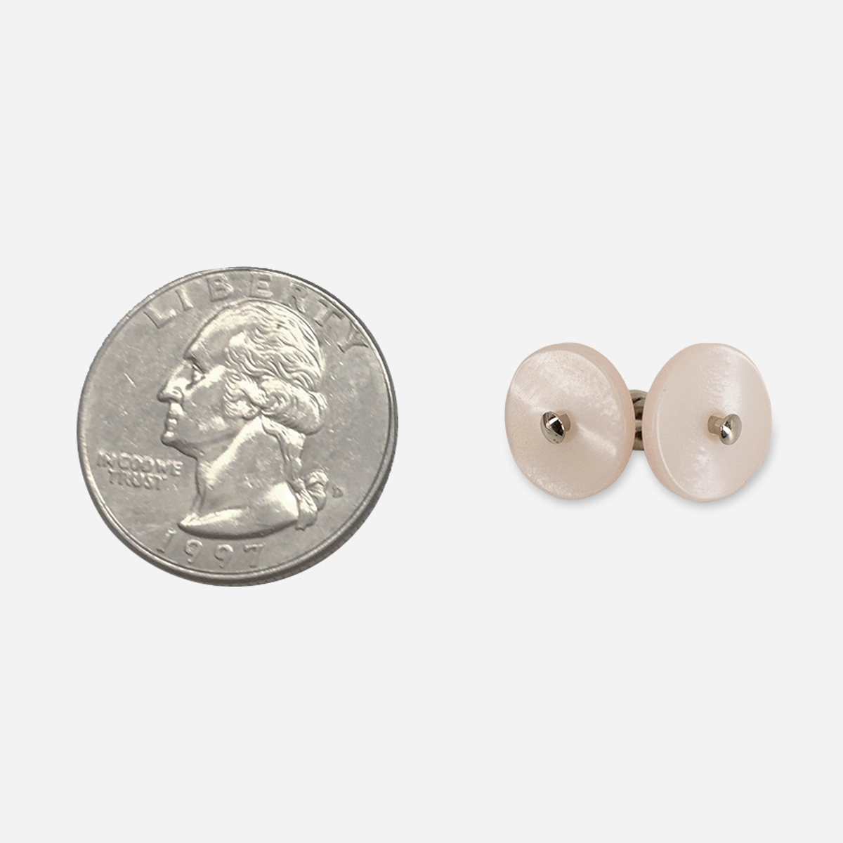 Vintage pink Lucite-style cufflinks shown beside a quarter for scale.
