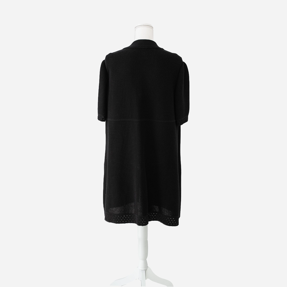 Black Chanel jacket Back view of Chanel black cotton knit jacket showing relaxed A-line silhouette, short sleeves, and perforated hem trim.