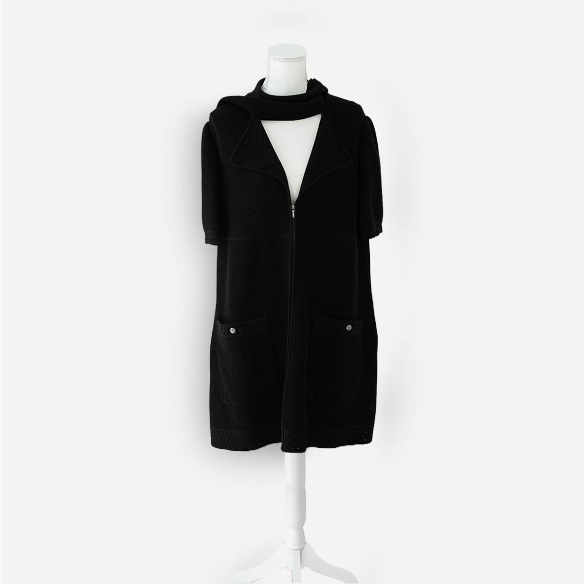 Chanel black zip-front cotton knit jacket on dress form, styled closed with neck tie draped around the collar.