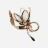 vintage milk glass flower brooch Vintage milk glass flower brooch with white petals and rose gold-tone ribbon setting.