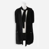 hanel Black Perforated Knit Neck Tie Detail Zip-Front Dress Chanel black perforated knit jacket worn open on dress form with self tie collar hanging loose and front patch pockets visible.