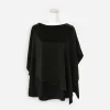 Front view of black wool-blend poncho top with layered draped hem