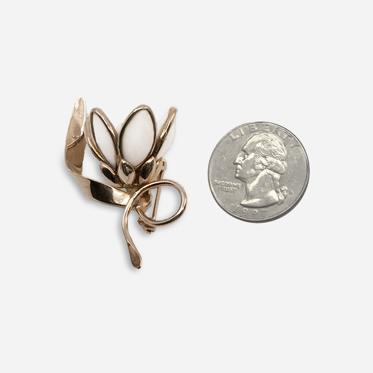mall vintage milk glass flower brooch shown beside a quarter for scale