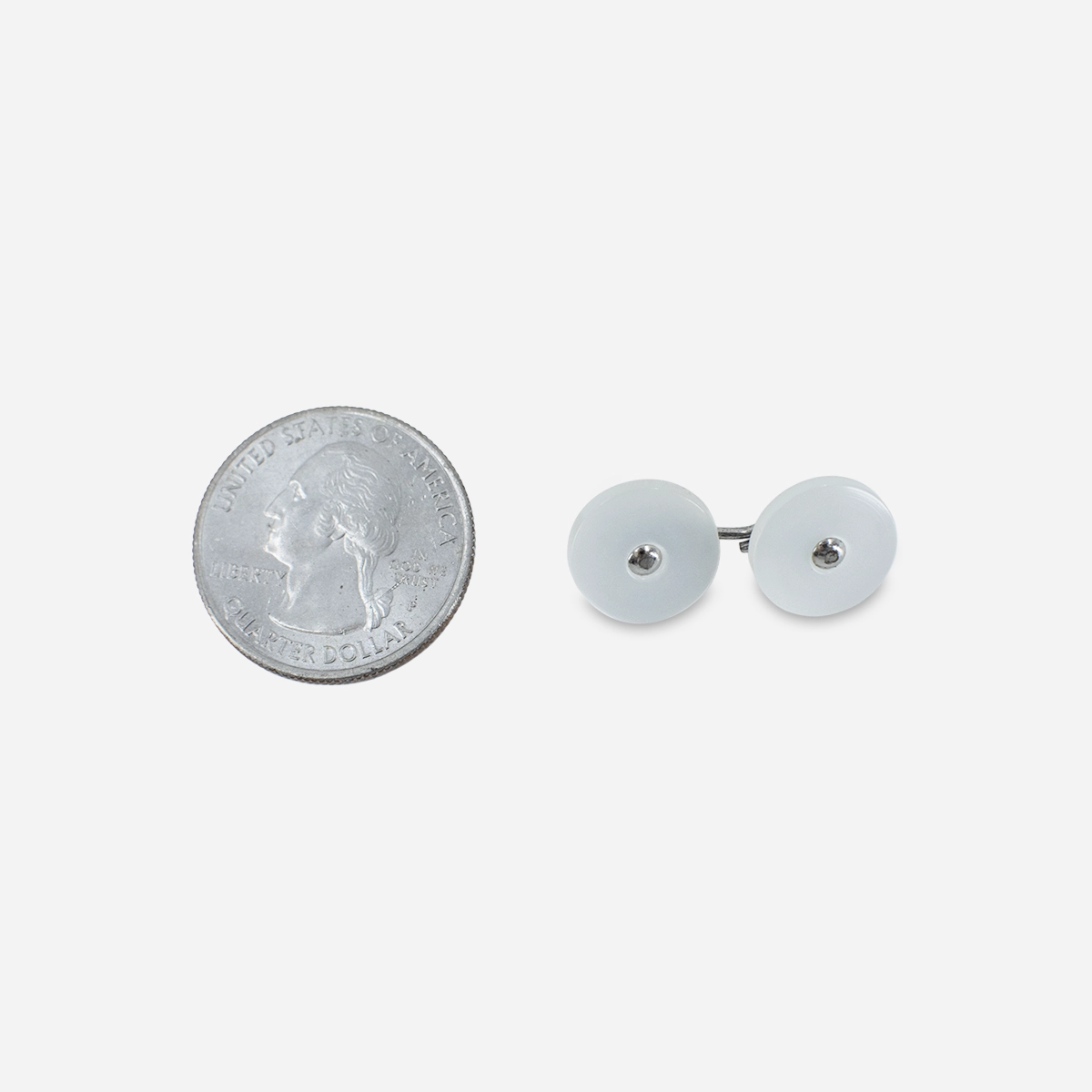 Vintage white Lucite cufflinks shown beside a quarter for scale.