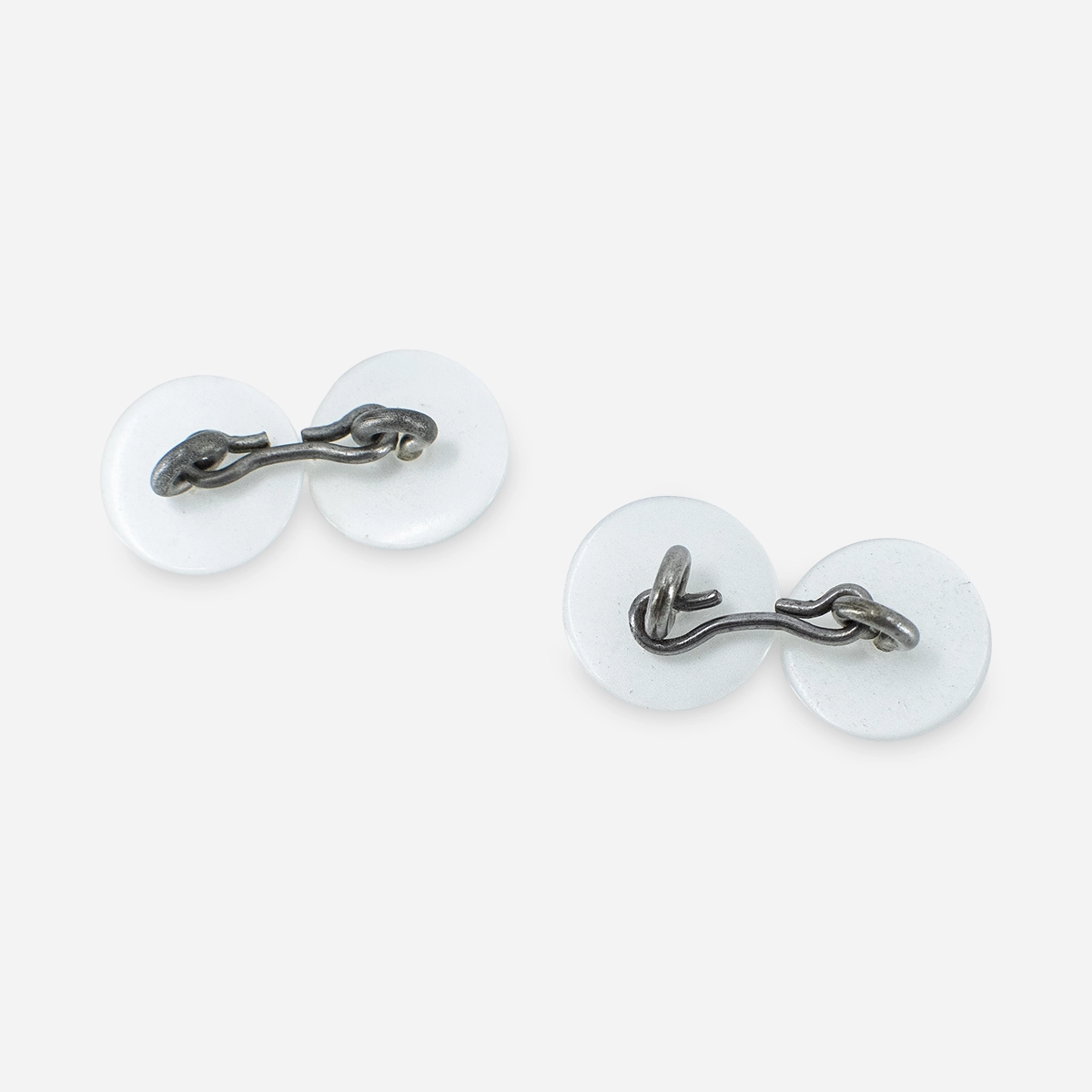 Back view of 1950s white Lucite cufflinks with fixed bridge metal construction.