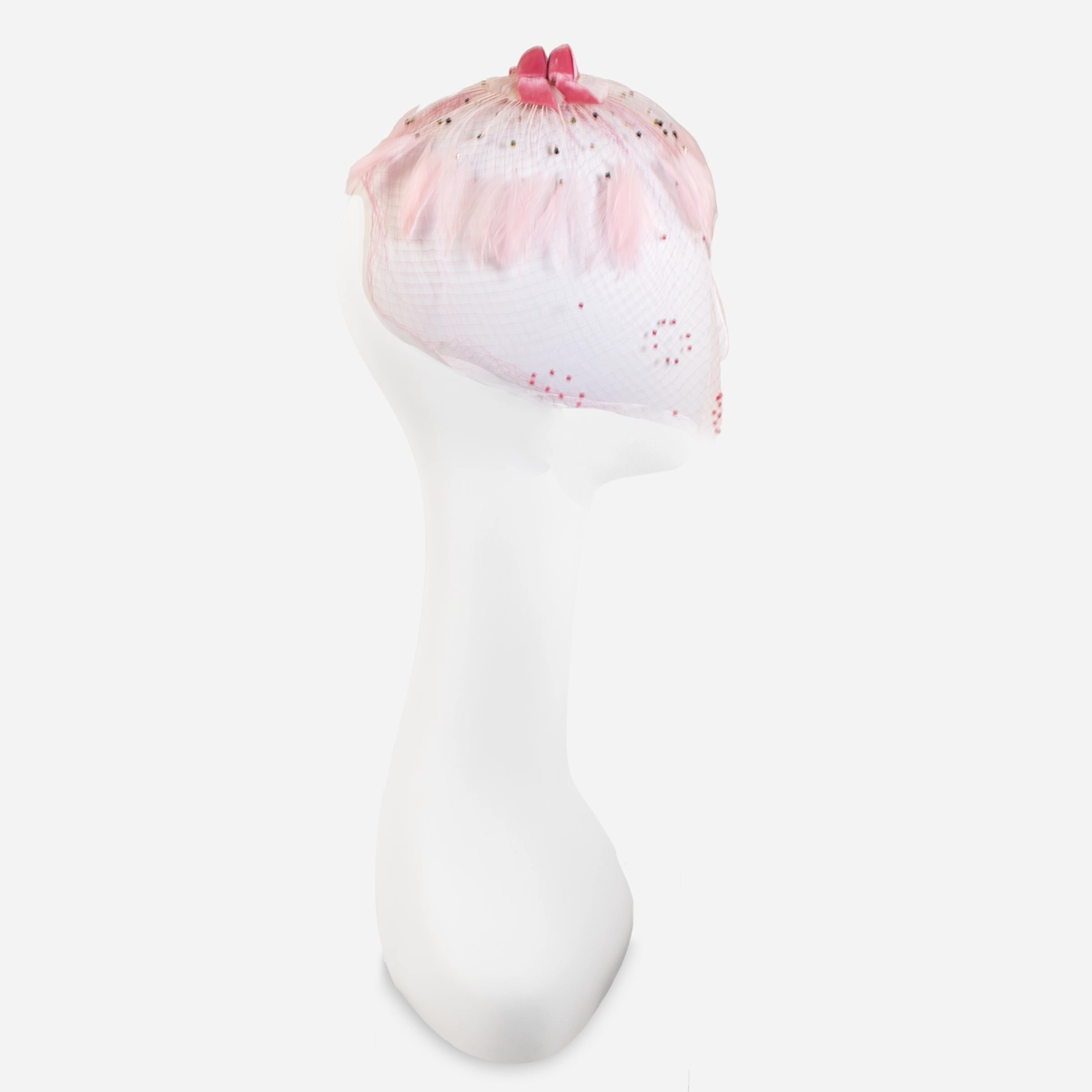 1950s pink whimsy hat Side view of pale pink feather whimsy hat with full face veil