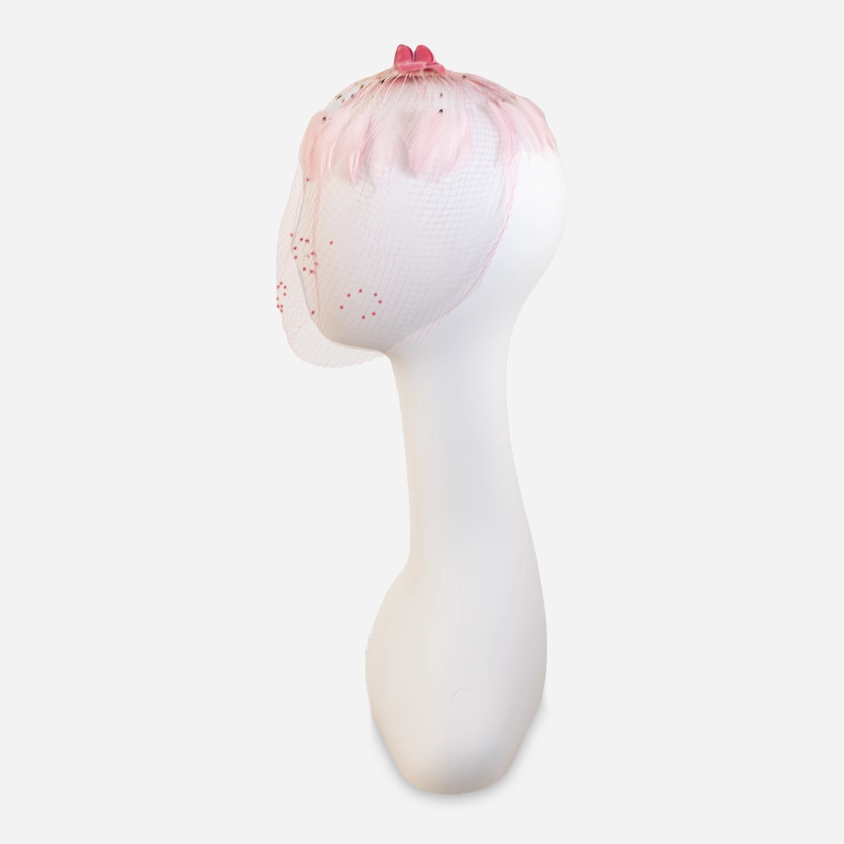 vintage 1950s pink hat 1950s pink feather whimsy hat shown from the side with its dotted veil falling over the face